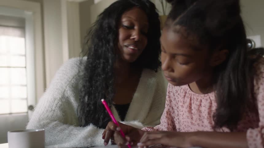 A mother is helping her daughter with homework