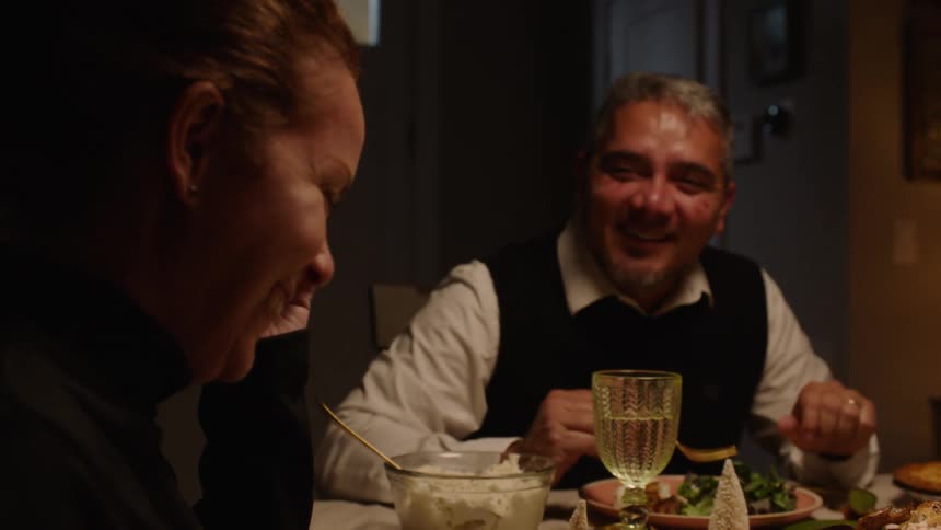 People at a dining table talking and smiling