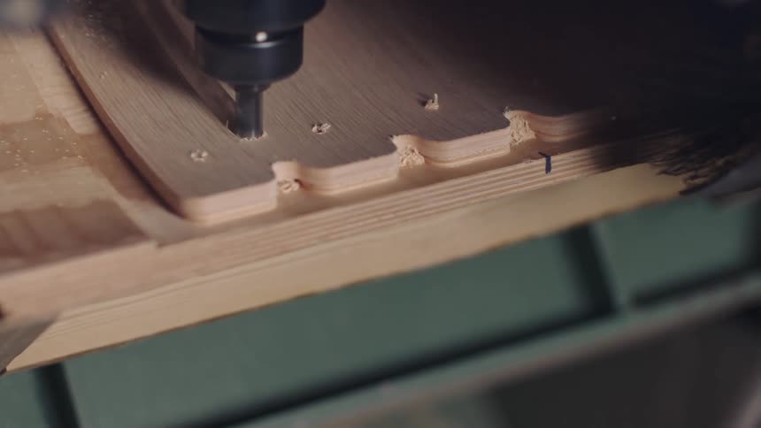 Machine performing a precise cut on a wooden board