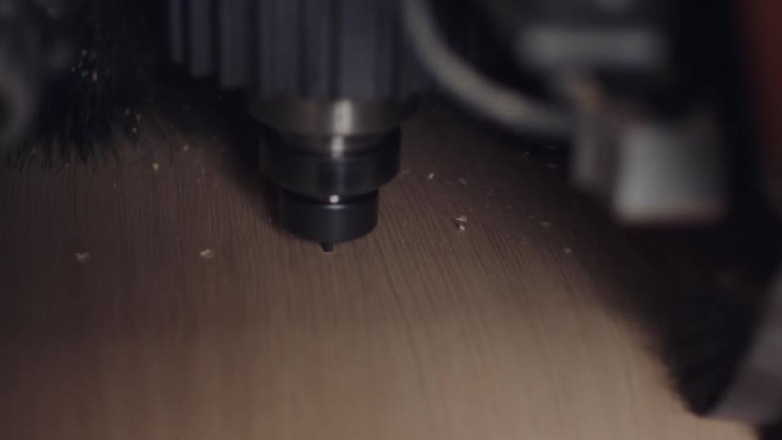 A woodworking machine drilling a piece of wood in a detailed closeup shot