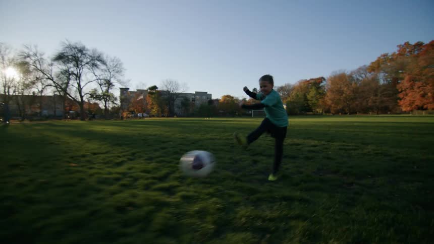Two boys playing soccer on a grassy field