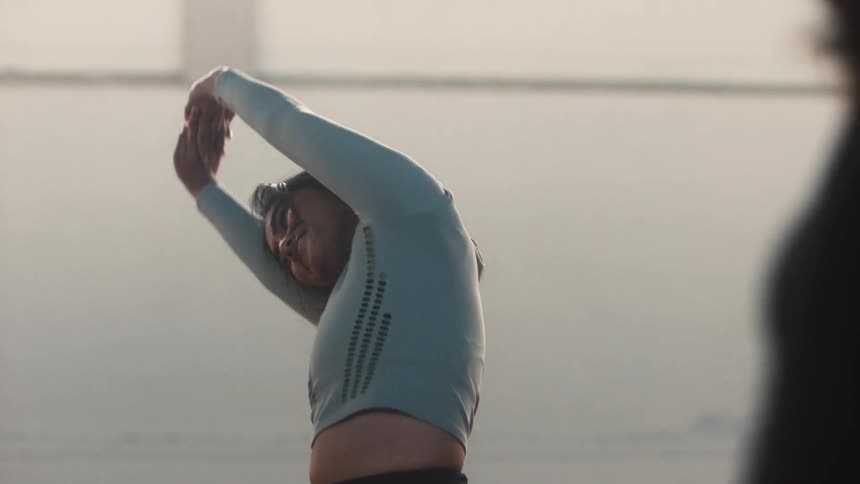 Two dancers are stretching together