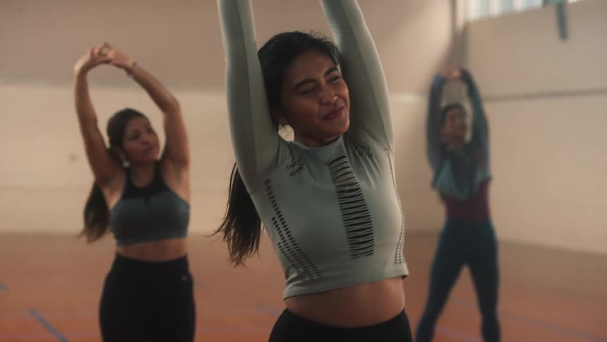 A group of three women are stretching their arms