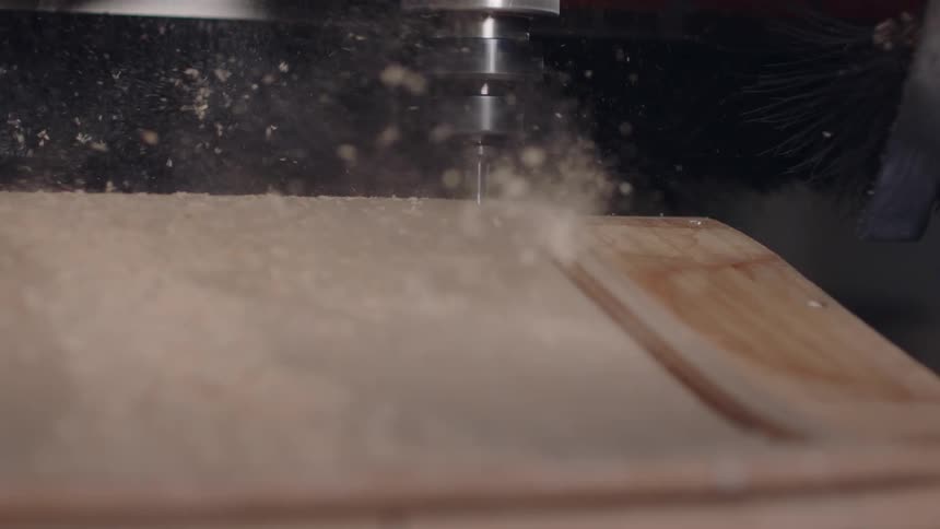 Machine performing a precise cut on a wooden sheet