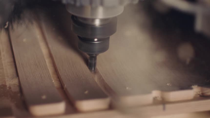 Closeup of a machine making a cut on a wooden board
