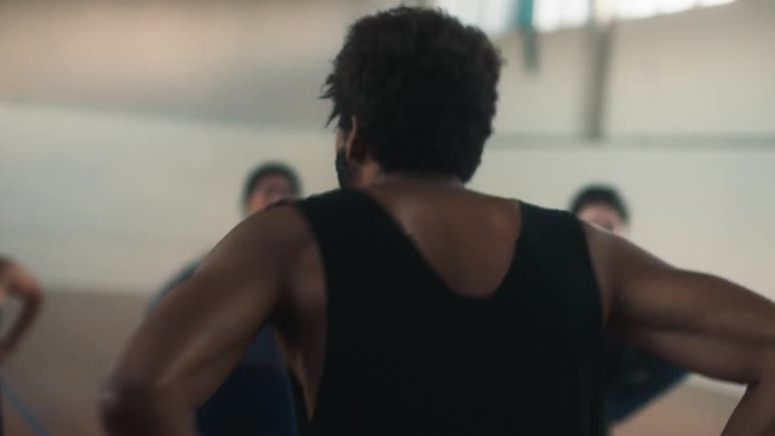 Man facing away and toward the women motivating them to continue the cardio movement