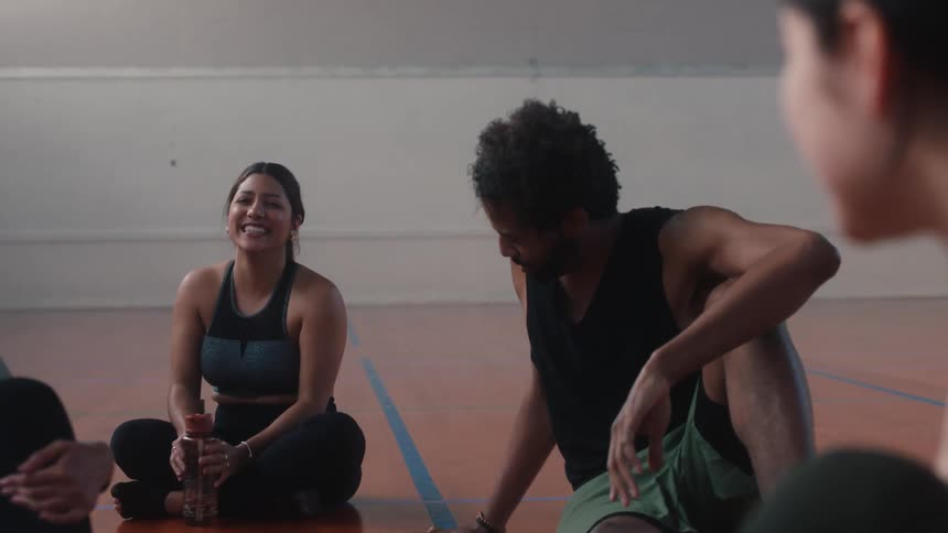 Friends sitting on a court chatting and smiling