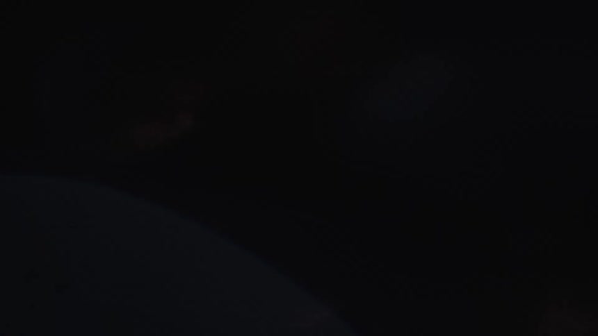 A metallic object rotates quickly as light reflects off of its surface