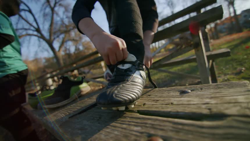 Closeup of a soccer cleat being placed on a boys feet
