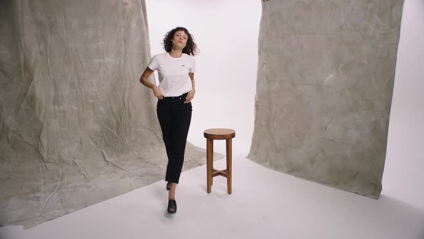 Woman modeling for the levis brand in a studio with a central stool