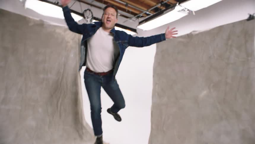 A man wearing a denim jacket and jean briefly poses during a photo shoot photo white cyc photography apple box quirky levi jeans