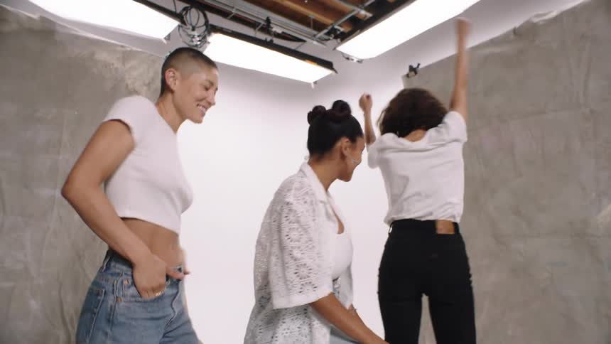 Three female models in a studio dancing while modeling