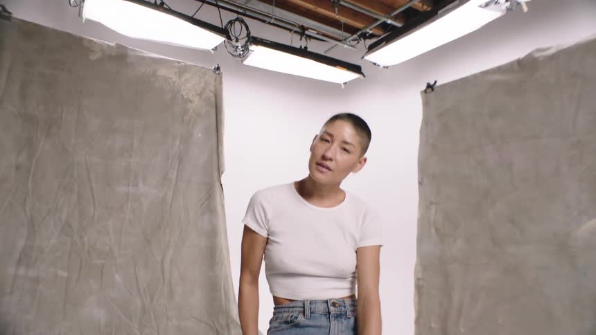 A smiling woman sitting on a bench in the photography studio