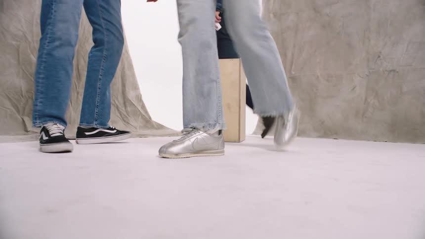 Legs of people walking around after posing on a set indoor
