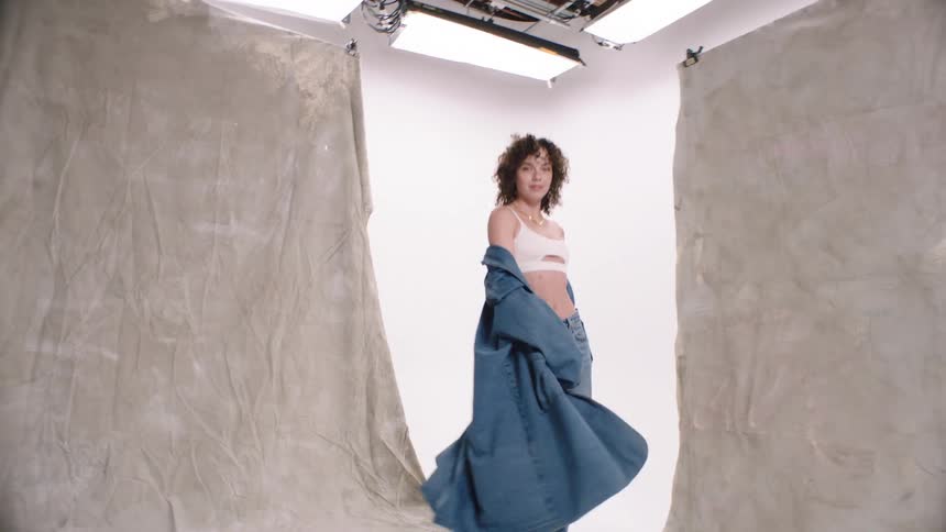 A woman dances while modeling clothing photo white cyc studio jumping