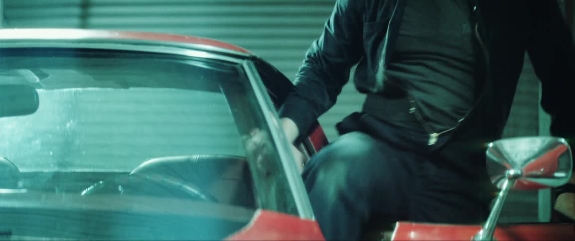 A man getting into a car parked in the garage