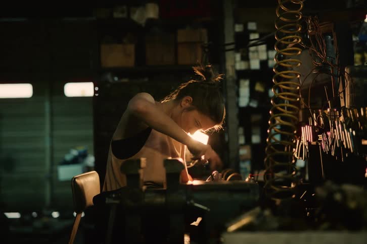 A woman repairing a car engine in a garage