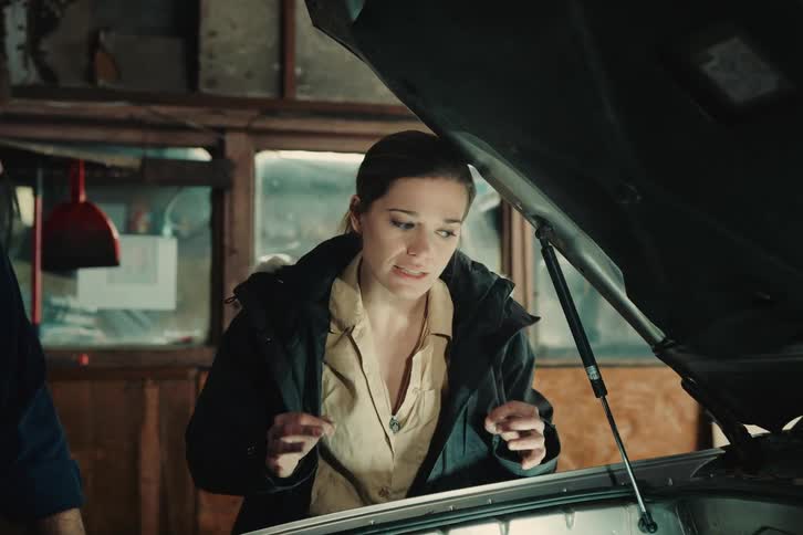 Mechanic standing next to the customer with the car hood open having a conversation