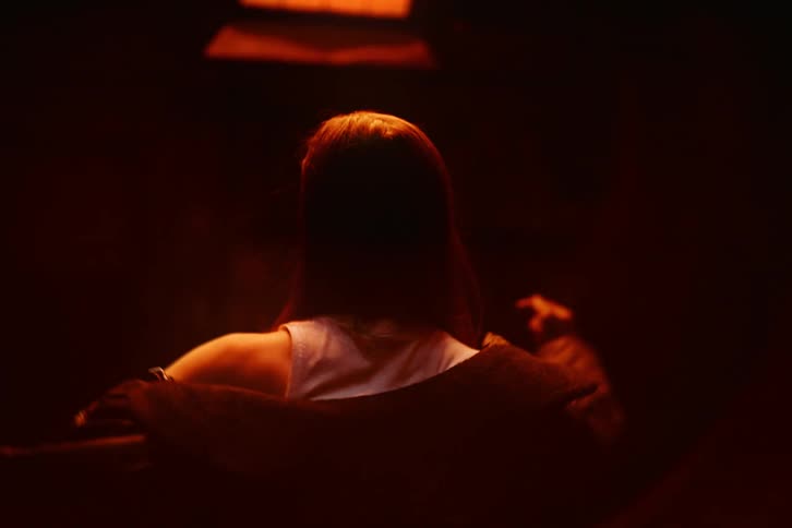 Woman seen from the back putting on a jacket