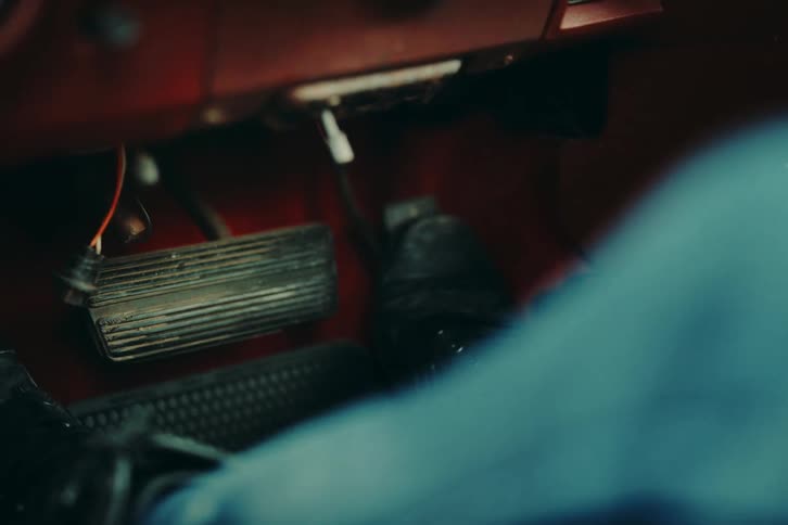Closeup on a mans feet pressing the accelerator and brake pedals in a car