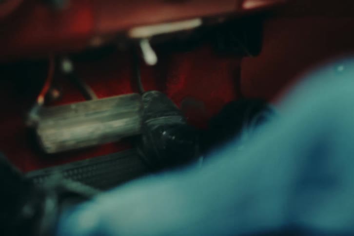 Feet of a person pressing hard on the accelerator and brake pedals