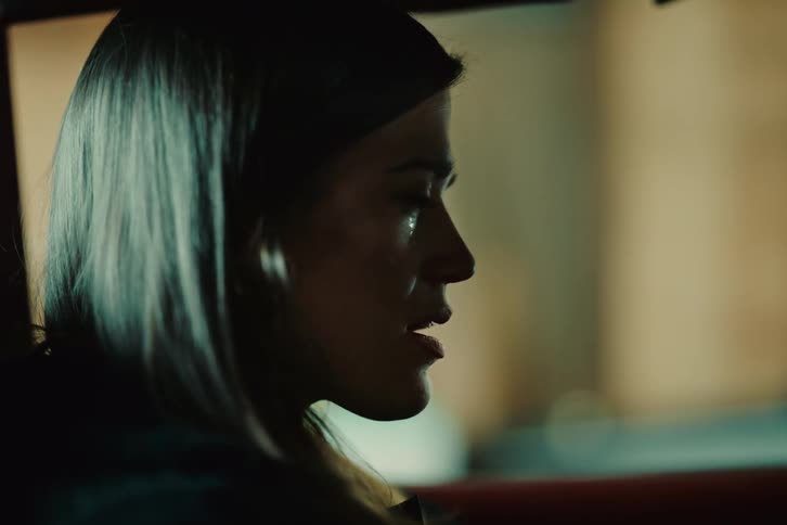 A woman inside a car cries with happiness as she turns the key to start it