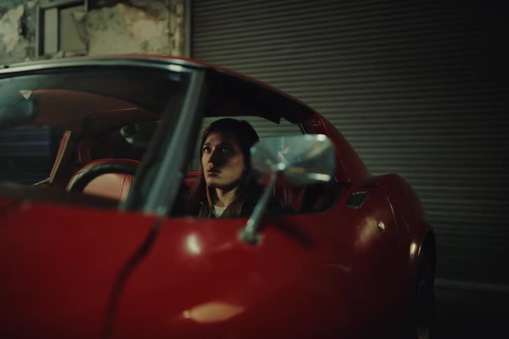 A lady inside a red car