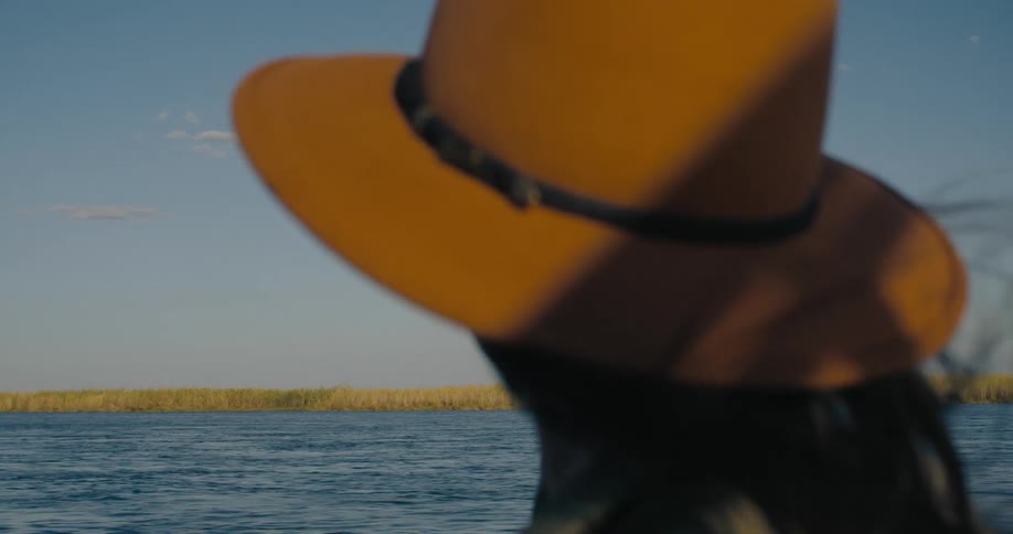 A woman watching the sea in the savanna on a sunny day