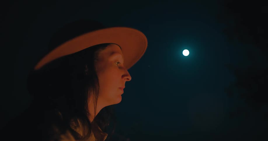 The face of a woman looking at the sky where the moonlight is
