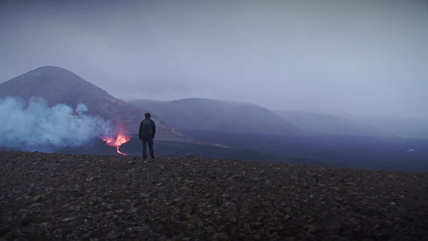 A person is watching a volcano erupt