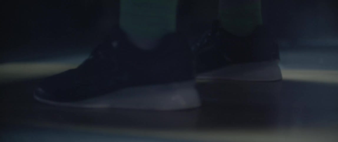 Person lifts weight and drops it in dimly lit gym