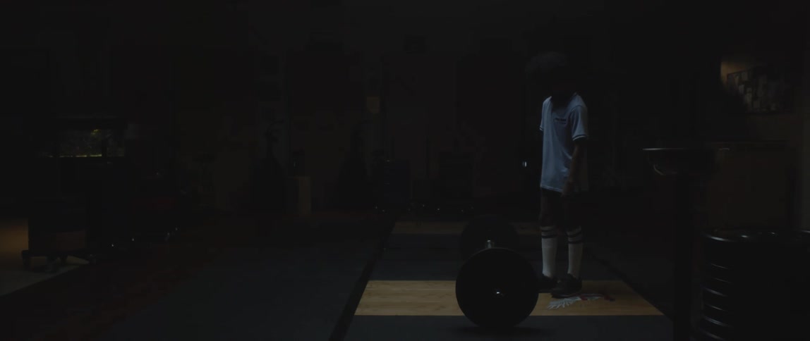 A clip of a teenager squatting beside a weight