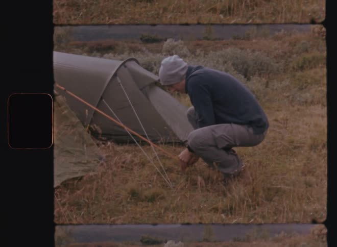 A man setting up his camp tent