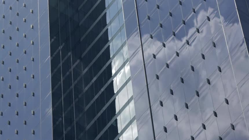 The windows on this building are mirrors reflecting clouds