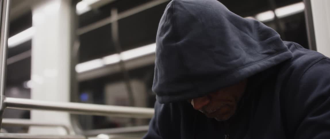 A close up clip of a mans face covered with black hood