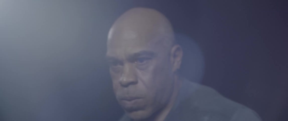 A man is walking back and forth in the dark