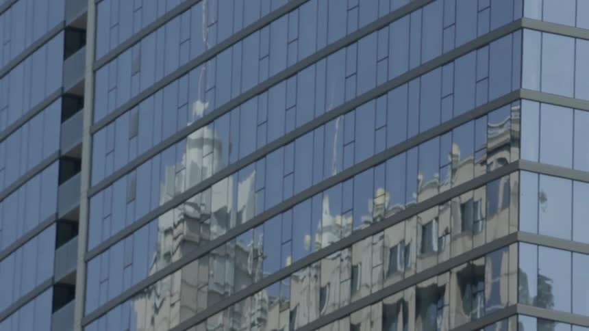 Buildings reflected in a large skyscraper