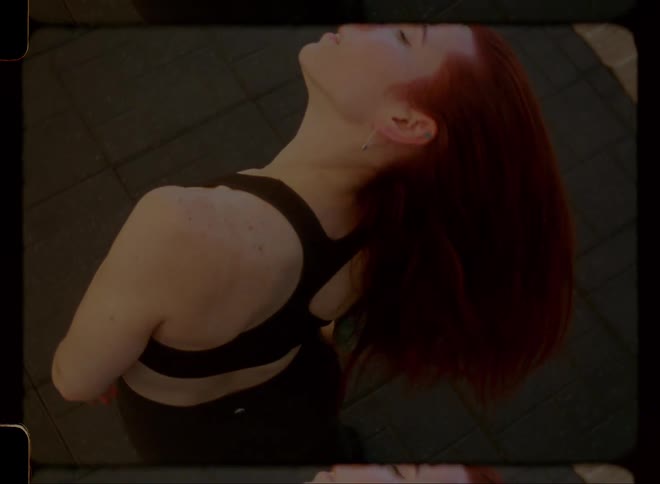 Woman lifting her head with her red hair and spinning