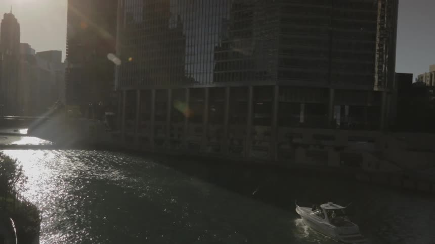 A boat is sailing in the water near tall buildings
