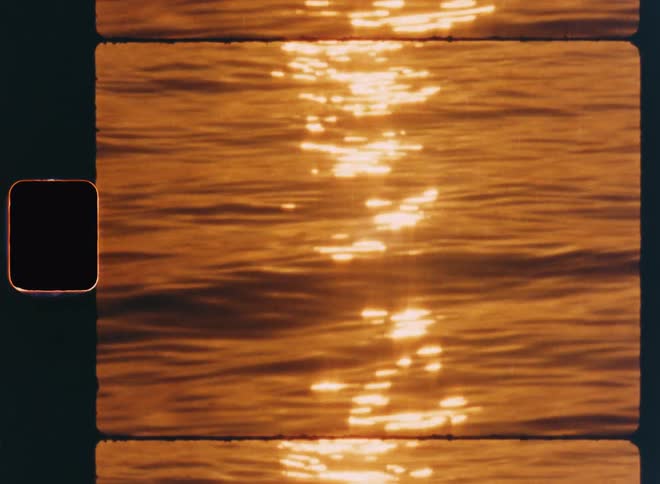 A person fishing in the calm sea at sunset