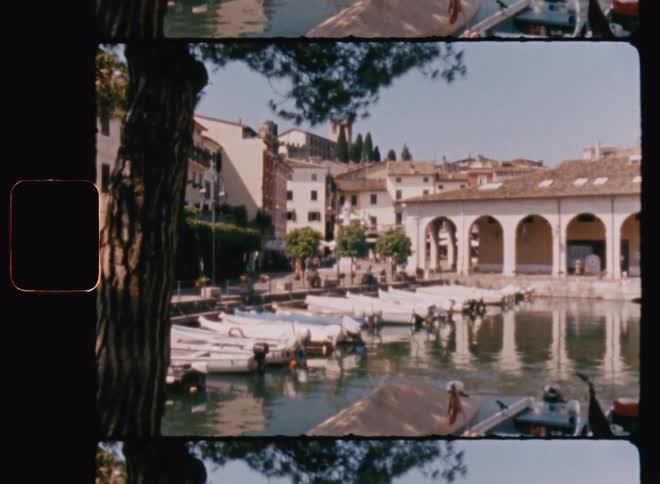Small motorboats are docked in a marina on a clear sunny day