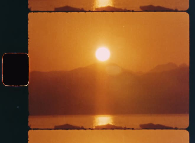 Landscape of the sun rising under the mountains and reflecting in the lake