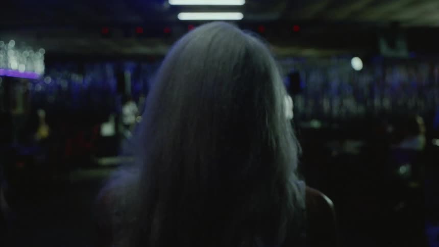 A woman walking through the nightclub