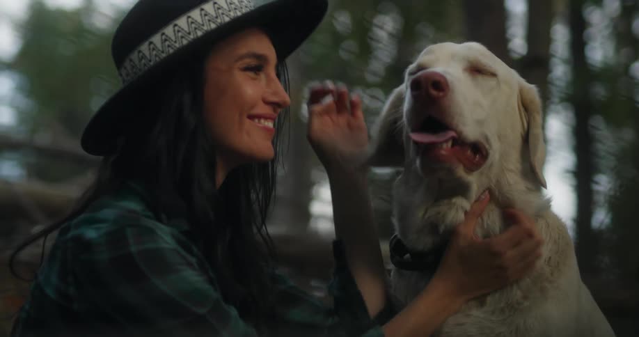A woman petting kissing and hugging a dog