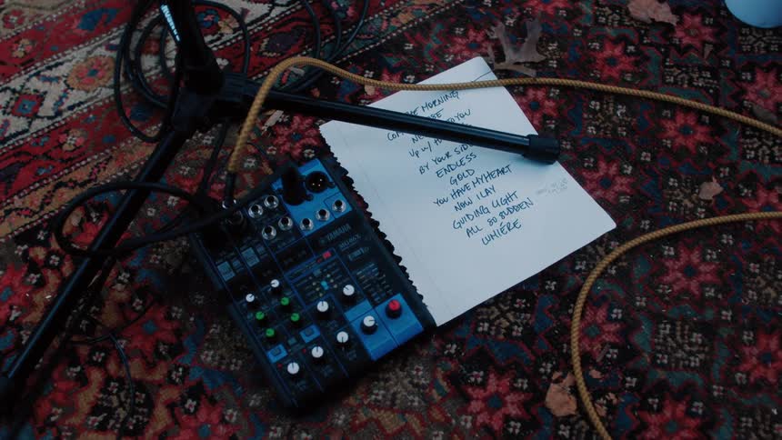 A list next to an electronic audio device on the floor