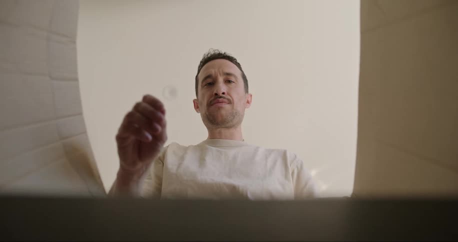 A man opens up a cardboard box and removes a single mug from it