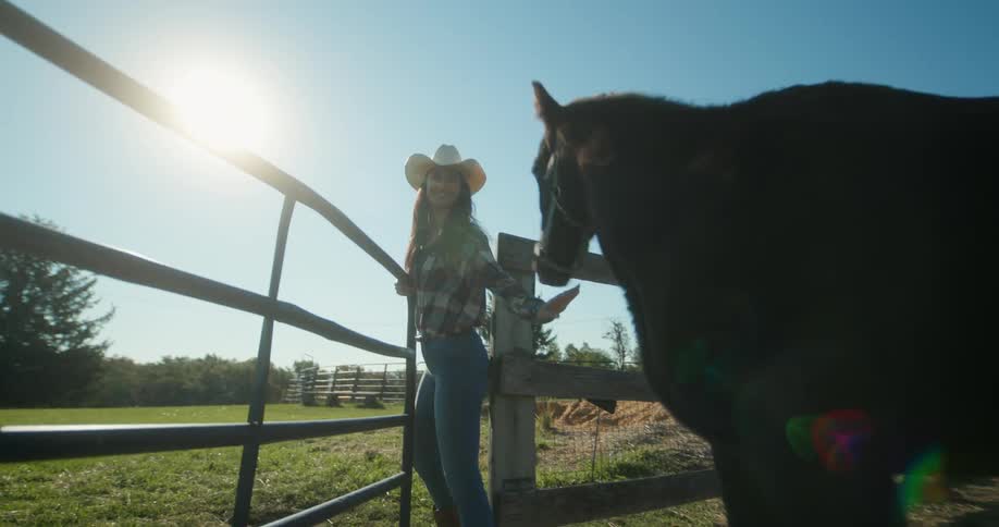 A woman leads the horse past the gate