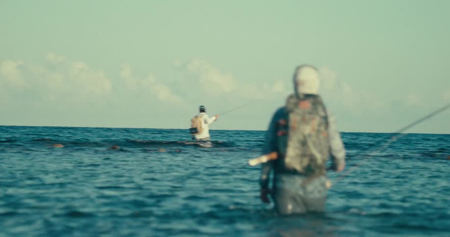 Friends fishing in the sea at high tide during the day