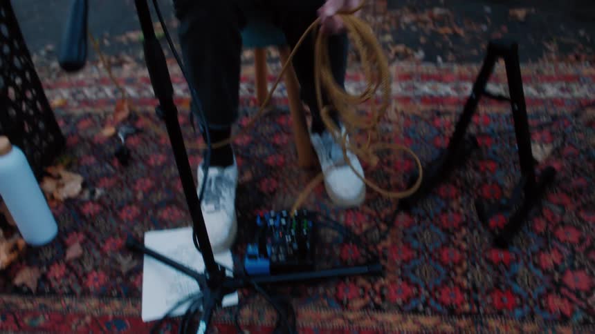 Female singer grabbing her guitar and getting ready in the backyard of a house
