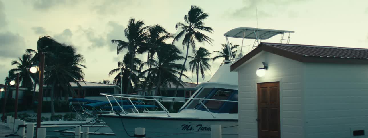A moored boat is confused by the wind in a marina
